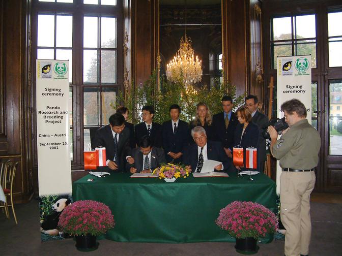 Menschen unterzeichnen vor der Presse einen Vertrag