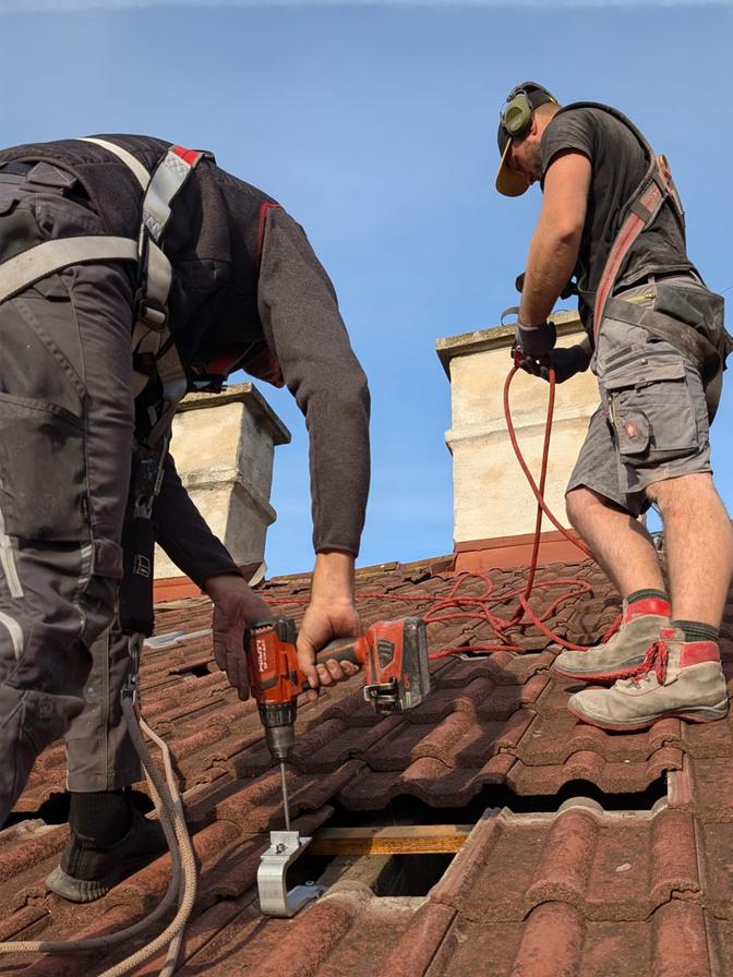 Zwei Arbeiter bereiten ein Dach für die Montage einer Solaranlage vor.
