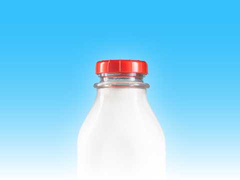 Eine Flasche Milch vor einem blauen Hintergrund.
