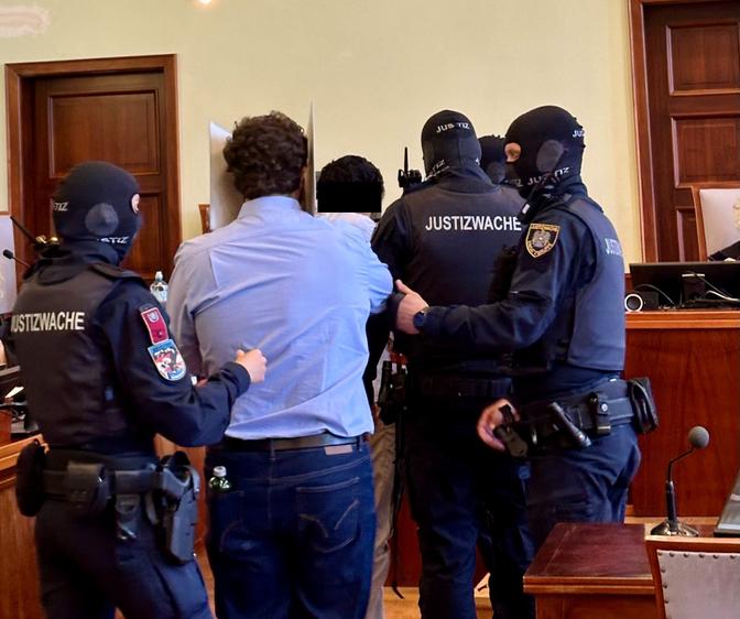 Justizwache führt den Angeklagten Beran A. am Urteilstag im Terrorprozess rund um die abgesagten Taylor-Swift-Konzerte in den Gerichtssaal.