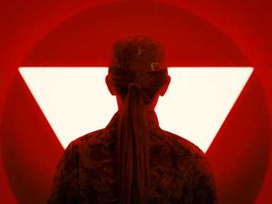 Silhouette einer Person in Tarnuniform vor einem roten Hintergrund mit einem auffälligen weißen Dreieck.