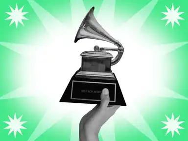 Eine Hand hält eine Grammy-Trophäe mit der Aufschrift "BEST NEW ARTIST" vor einem grünen Hintergrund mit weißen Sternmotiven.