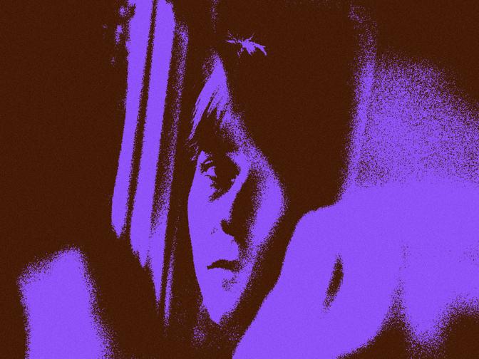 Eine Frau, die ihr Gesicht in einem zerbrochenen Spiegel betrachtet.