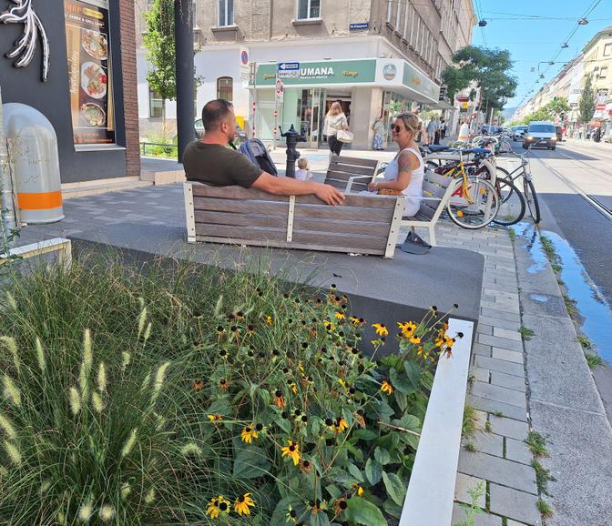 Ein Paar sitzt auf einer Bank an der Thaliastraße