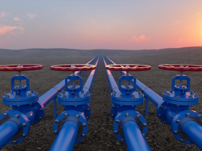 Gastransport mit blauen Gas- oder Rohrleitungsventilen auf Boden und Sonnenaufgang Hintergrund