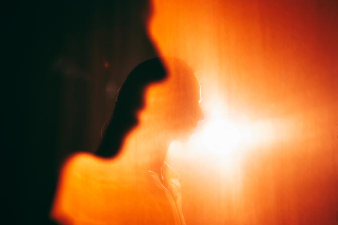 Stimmungsbild. Personen in einen rot erleuchteten, hitzeerfüllten Raum.